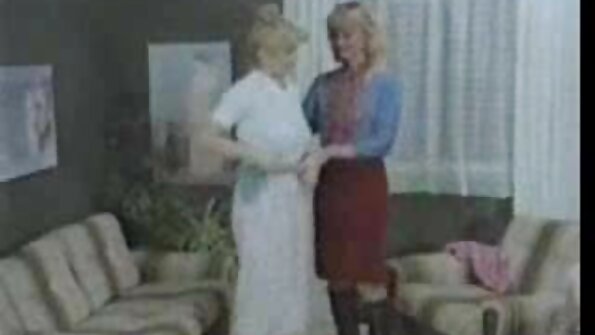 കറുത്ത ചുരുണ്ട മുടിയുള്ള ഒരു സുന്ദരി സോഫയിൽ ആഴ്ന്നിറങ്ങുന്നു